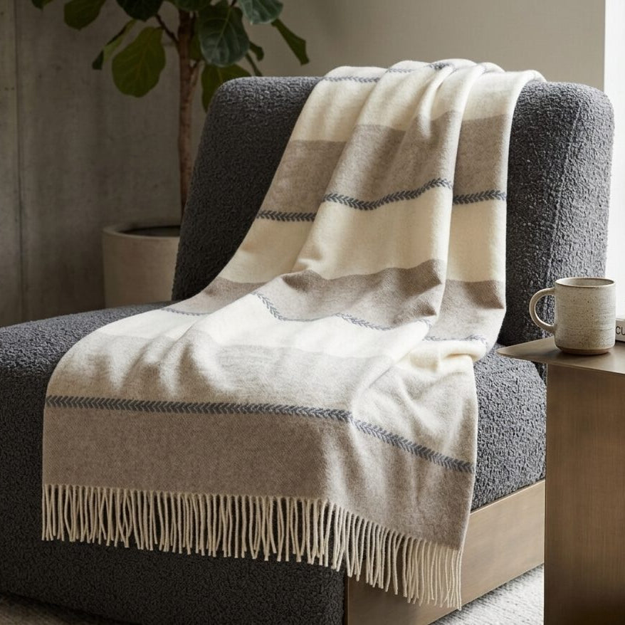 Pleds FARO K, 140x200, 90% merino vilna, 10% kašmirs, avītrains, balts-bēšs-brūns interjerā